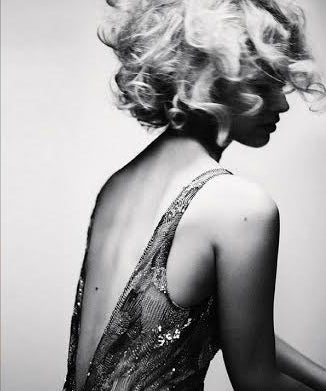 Black an white image of a blonde woman wearing a backless dress
