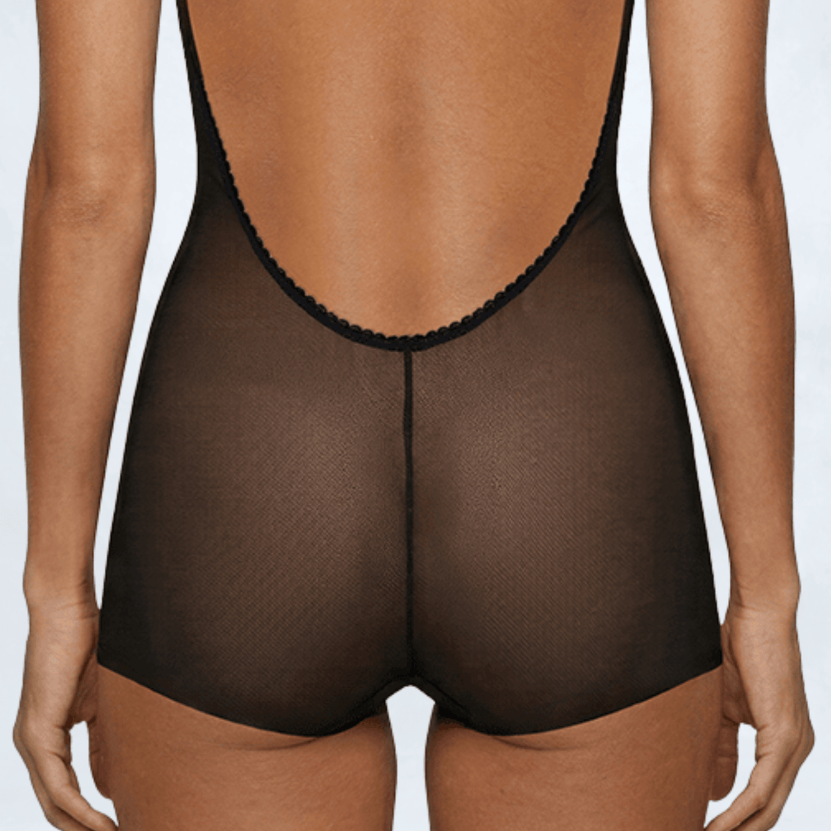 Close-up back view of the Ender Legard KYA Black bodysuit showing the ultra-low scalloped back edge, centre-back seam and full-brief seat coverage with flat laser-cut leg edges.