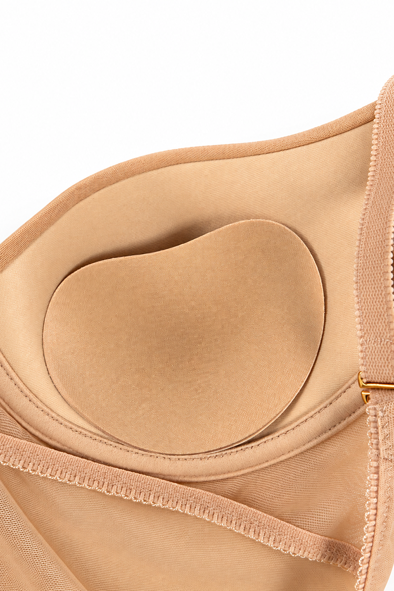 Close-up view of a pair of nude coloured fabric bra inserts in an ENDER LEGARD MAE backless shapewear bodysuit.