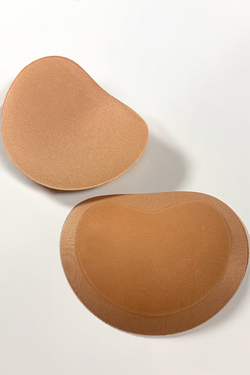 Close-up view of a pair of nude coloured padded fabric bra inserts