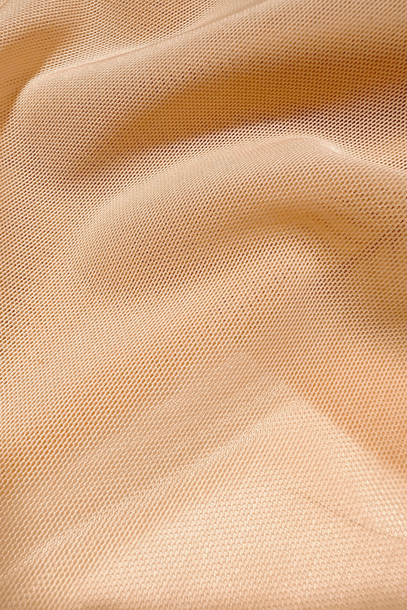 Close up of beige power mesh fabric used in Ender Legard backless bodysuits showing the fine detail and breathability of the material.