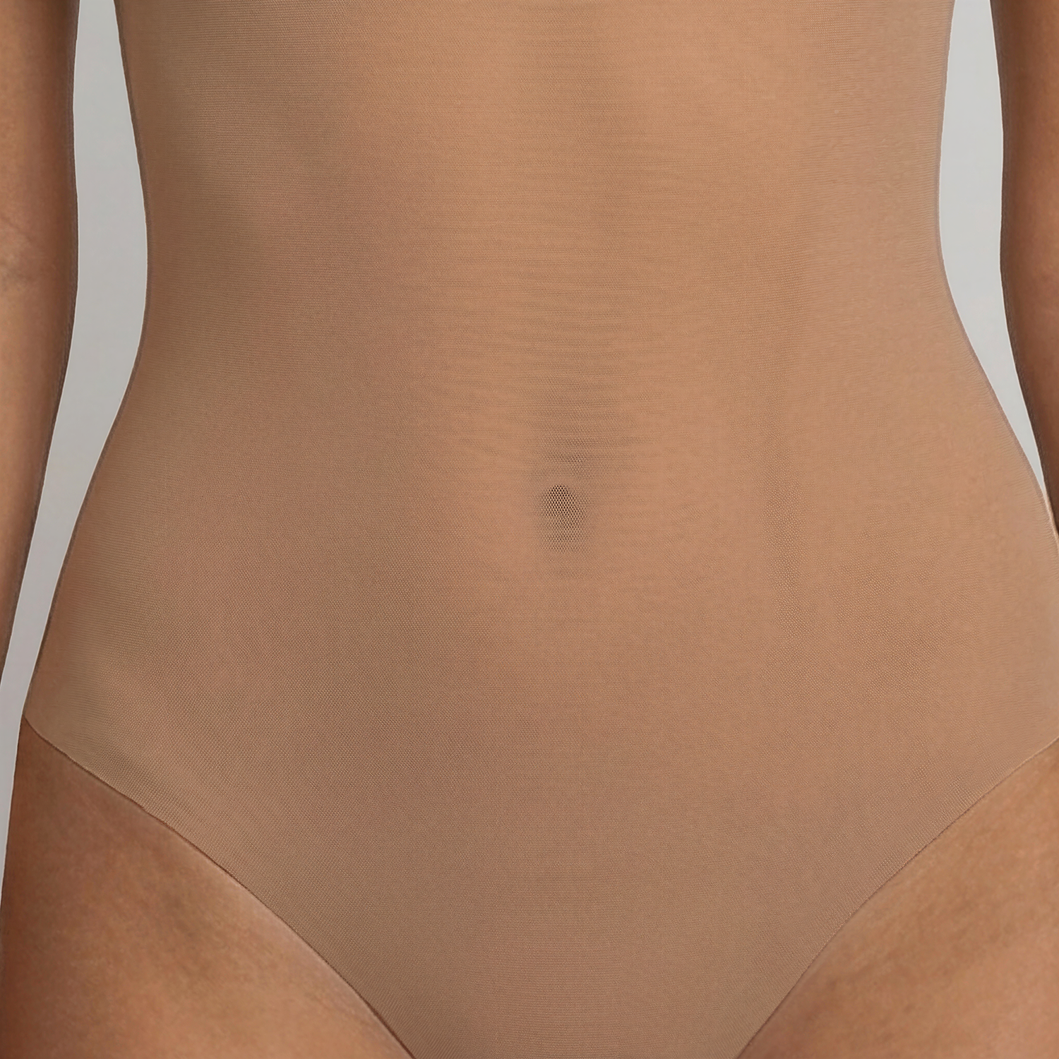 Close-up of LEXI Nude showing the fine power-mesh front and the laser-cut high-leg edge lying flat against the hip.