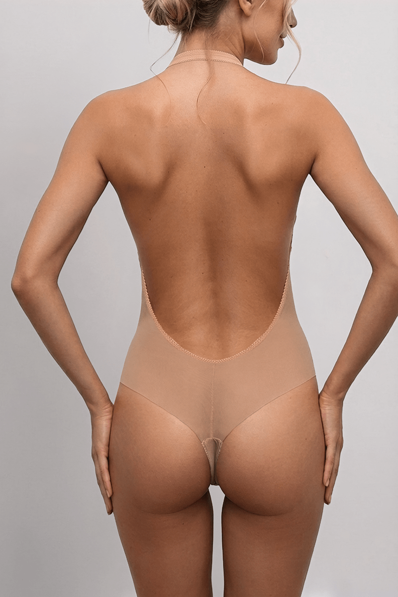 Studio back view of LEXI Nude showing the ultra-low back, single neck strap and high-leg tanga with its centre-back seam.