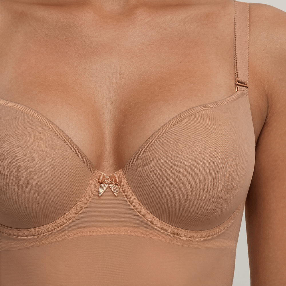 SIA Nude backless bodysuit close-up of the balconette cups, showing the smooth moulded surface with no seam, pleat or dart, and the small bow at the centre.