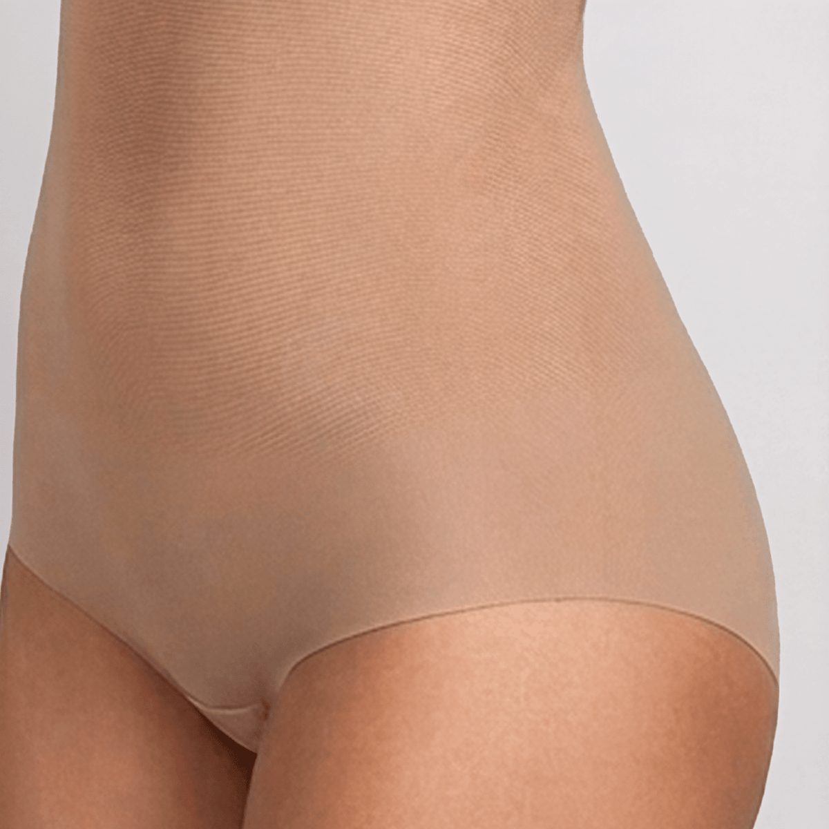 SIA Nude backless bodysuit close-up of the hip and waist, showing the smooth power-mesh fabric and the edge of the full brief at the leg opening.