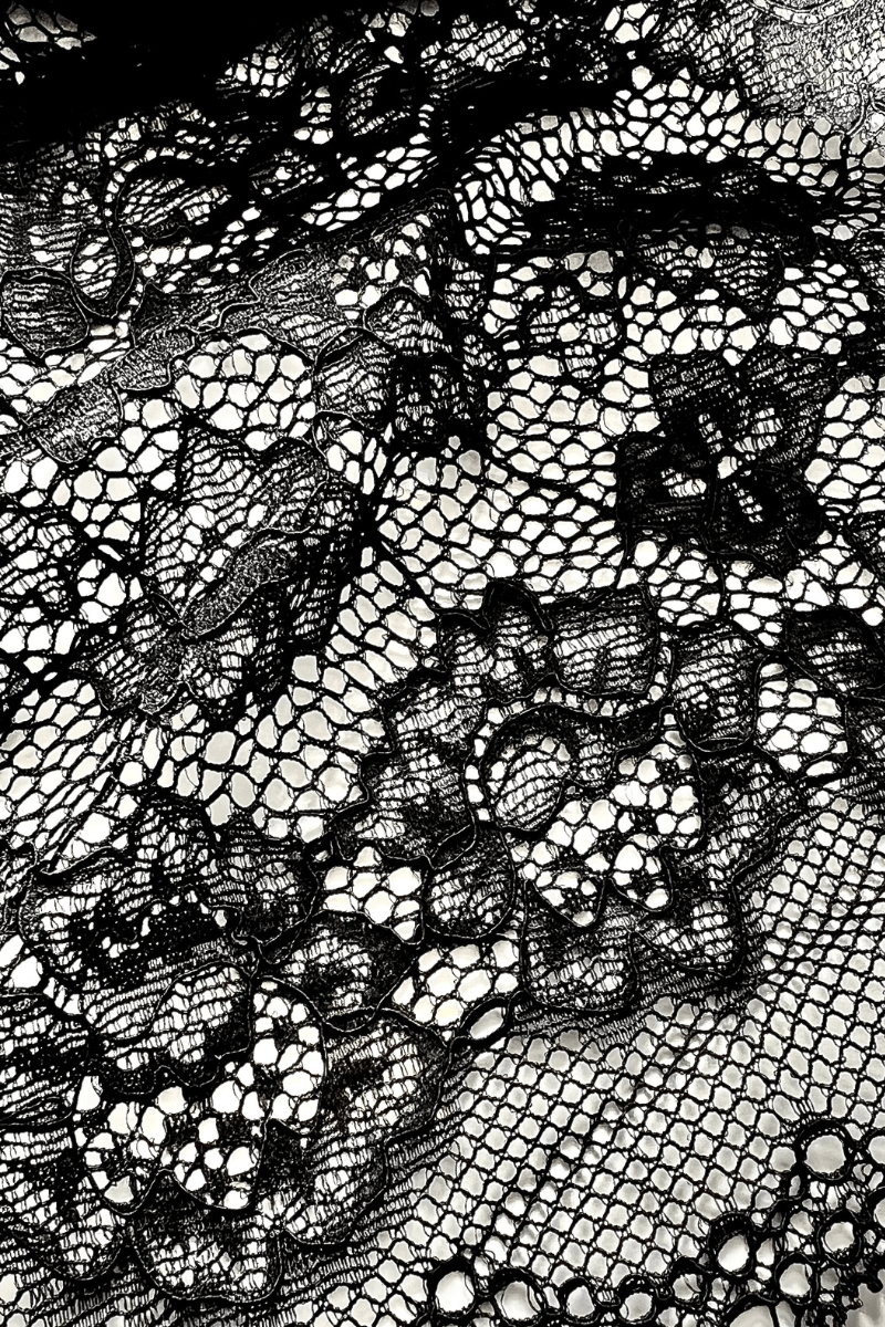 Close-up of the UMA Black stretch lace fabric, showing the floral lace pattern and texture.