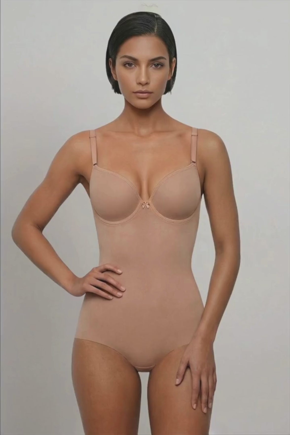 Ender Legard SIA Nude backless bodysuit shown in motion from front through side to back, demonstrating the seamless cup, no bra back band, ultra-low back and full-brief coverage.